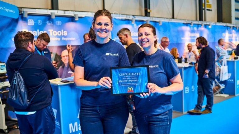 maverick employees holding certificate at trade stand